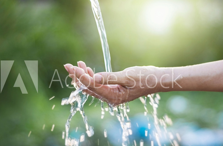 !B Ein Wasserstrahl läuft auf eine geöffnete Handfläche
