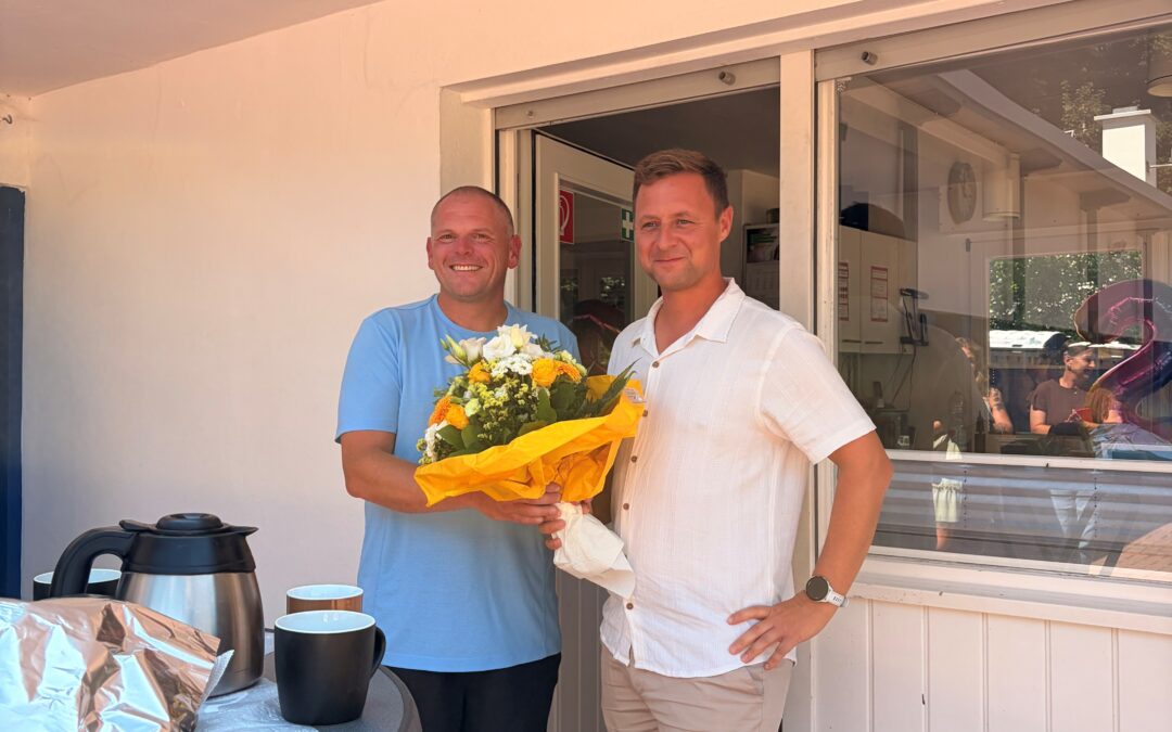 !B Marketingleiter Stefan Schöbel überreicht dem Jubilar einen Blumenstrauß